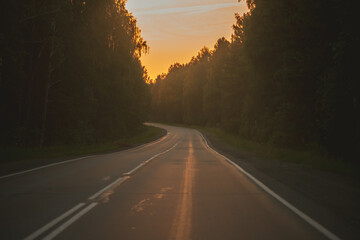 Naklejka premium The asphalt road goes into the distance On the Sunset