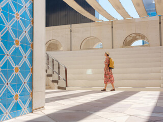 Young woman exploring Qasr Al Hosn Park in Abu Dhabi. Surrounded by lush greenery and historical landmarks, she enjoys the serene atmosphere and Emirati heritage in heart of city.