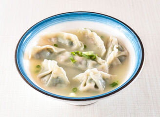 Leek and Pork Soup Dumplings topped with scallions served in bowl isolated on white background side view of hong kong food
