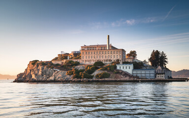 Naklejka premium Alcatraz Island at sunset, showcasing the infamous prison and surrounding waters.