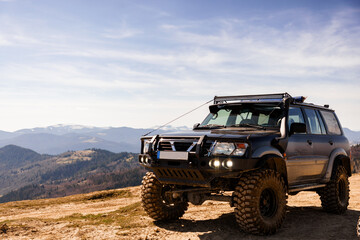 Fototapeta premium Off-Road Adventure: Rugged SUV on Mountain Terrain