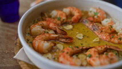 Delicious shrimp dish in garlic sauce served in a rustic restaurant setting showcasing vibrant and appetizing seafood cuisine