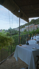 Outdoor dining in a mallorca restaurant with white tablecloths, beautiful nature, and a relaxed evening ambiance set in spain