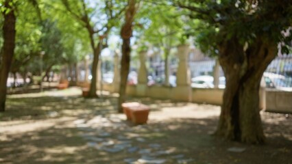Defocused outdoor park scene with blurry trees and benches in a sunlit garden