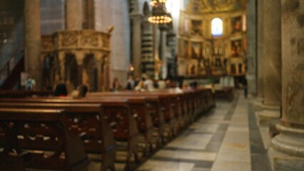 Fototapeta premium Blurred church interior with defocused pews and religious decor, capturing serene atmosphere through bokeh effect highlighting indoor architecture and spiritual ambiance.