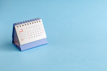 Desktop calendar for 2025 on a blue background. A place for the text.