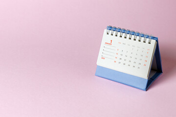 Desktop calendar on a pink background. The first day of the new year. January 1st.