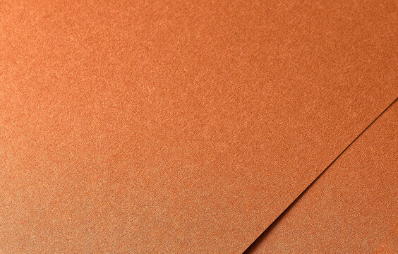 Copper paper texture with a metallic, glossy finish in warm tones of orange, brown, and terracotta. The grainy, layered surface with subtle shine and shimmer creates a rich,