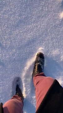 Beine und F&uuml;&szlig;e einer Frau wandern im Schnee in der Natur bei Sonnenaufgang