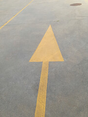 yellow arrow sign on concrete