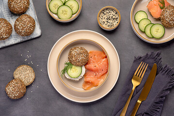 Food photography of sandwich with keto buns, low-carb bread, psyllium husk, sunflower, pumpkin and sesame seeds, almond flour, ketogenic diet, smoked salmon, soft cheese, cucumber