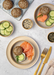 Food photography of sandwich with keto buns, low-carb bread, psyllium husk, sunflower, pumpkin and sesame seeds, almond flour, ketogenic diet, smoked salmon, soft cheese, cucumber