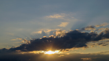 Fototapeta premium Summer evening sky in the picturesque clouds, lit by the rays of the setting sun.