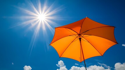Orange umbrella against a blue sky with the sun shining, banner background for sun protection and summer vacation