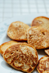 fried pancakes on plate on kitchen table, breakfast on sunny morning. healthy eating, vegetarian. top view of the food. nutritious lunch, delicious and balanced.