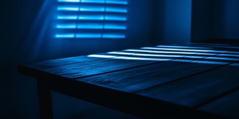 Obraz premium Dark wooden tabletop illuminated by soft blue light streaming through window blinds