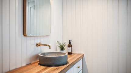 Fototapeta premium modern bathroom interior with a minimalist design. The layout features a wooden countertop with a round, gray stone sink basin.