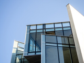 Design and construction of a modern building. Glass and concrete. Building of unusual geometric shape.