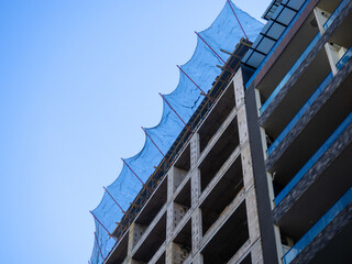 Construction nets on an unfinished building. Construction industry. Cement and concrete.