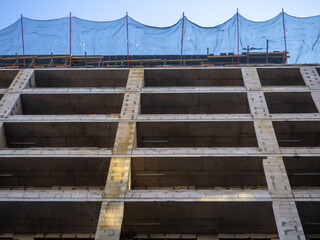 Construction nets on an unfinished building. Construction industry. Cement and concrete.