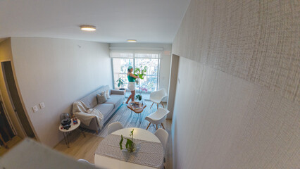 A person is standing in a living room with a potted plant. New home concept.