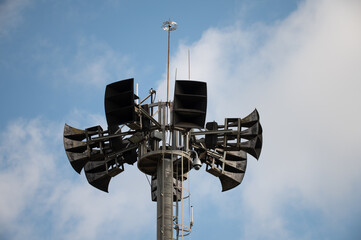 Detail of the upper part of a speaker and communications tower where large events are held, the tower has speaker antennas, horns, security cameras and other telecommunication devices