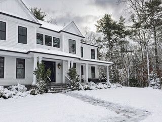 Snow covered suburban home - walkway and steps shoveled after an early winter snowstorm
