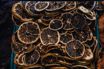 Close up of dehydrated lemon slices showcasing intricate textures and patterns, forming an interesting background in a market setting