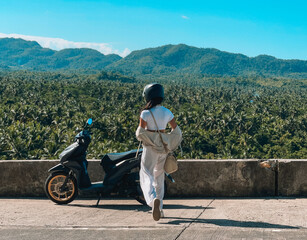 Adventurous Woman Exploring Siargao on a Scooter with a Stunning View of Palm Tree Forests and Mountain Landscapes © Maureen