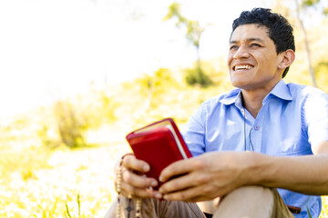 Fototapeta premium Christian man holding a Bible outdoors, reflecting tranquility and connection with God