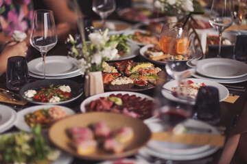 Brunch table setting with different delicious food and beverages ready for friends home party. A variety of food on the table, fish, olives, bread, raspberries, meat.