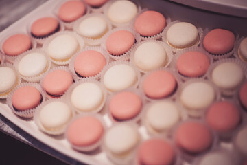 Macaroons pink dessert cake. Sweet candy bar for party. Delicate macaroons on a glass plate. Desser at a wedding candy bar