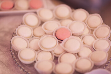 Macaroons pink dessert cake. Sweet candy bar for party. Delicate macaroons on a glass plate. Desser at a wedding candy bar