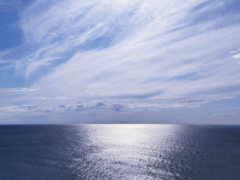Glittering ocean and beautiful cloudy sky horizon.