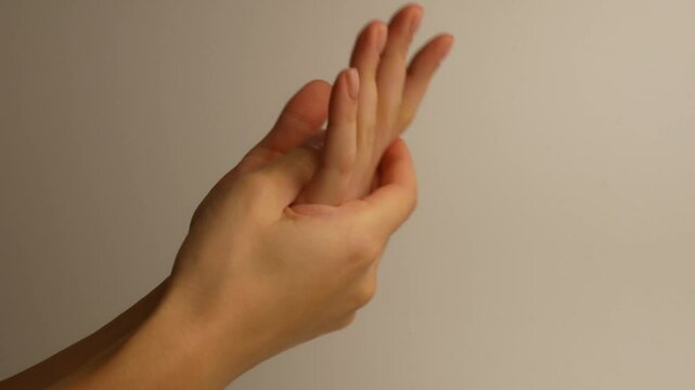 The girl moisturizes her hands by rubbing the cream on her palms.