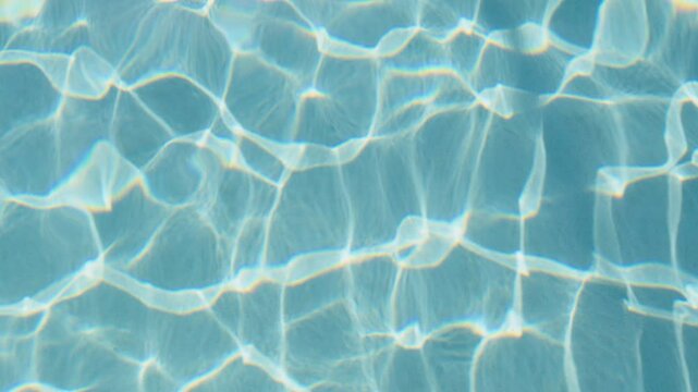Gentle waves ripple in the pool as sunlight filters through, casting mesmerizing patterns on the bottom. The tranquil water invites relaxation and reflection during a warm afternoon.