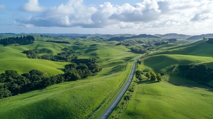 Fototapeta premium Lush Green Rolling Hills with Serpentine Road in Bright Daylight