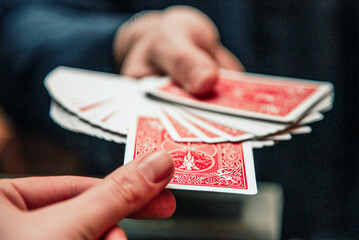 Magician show card trick, man play casino gambling, close up hands holding deck