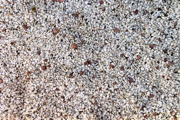 Close-Up of Crushed Gravel Texture. Detailed view of crushed gravel stones in white and brown tones, commonly used for landscaping, pathways, or construction projects.