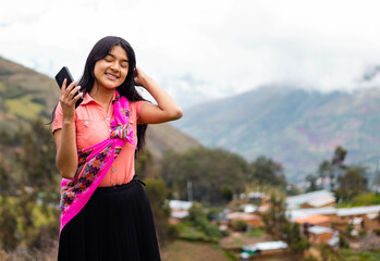 Mujer campesina atractiva en América Latina, feliz mientras usa un teléfono inteligente mirada a...