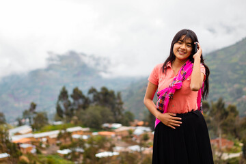 Mujer campesina atractiva en América Latina, feliz mientras usa un teléfono inteligente mirada a...