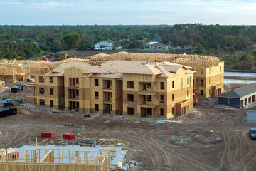 Wooden apartment buildings under construction in new developing suburban area. Development of...