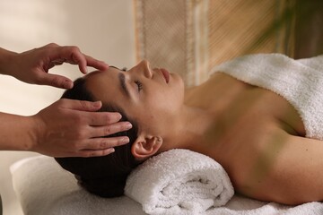 Woman receiving face massage in spa salon