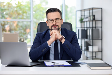 Naklejka premium Portrait of handsome banker at table in office