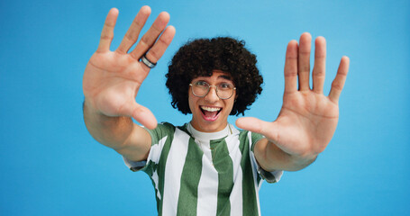 Selfie, smile and hands with portrait of man in studio for photography frame, social media and excited. Happiness, live streaming and profile picture with person on blue background for vlogger pov