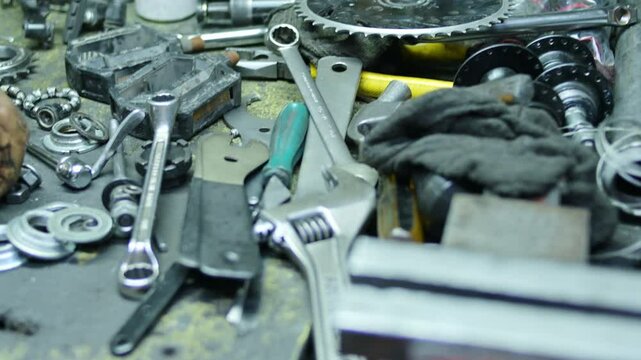 Panning messy mechanic desk with some different tools in bikeshop 