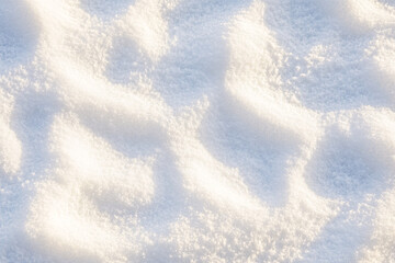 Obraz premium A close-up of soft snow mounds reflecting warm sunlight creating gentle shadows and intricate sparkling textures 