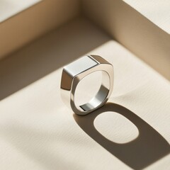Modern geometric silver ring with shadow on beige background