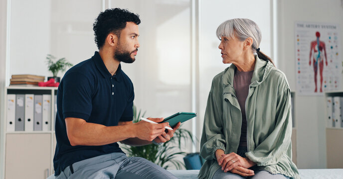 Tablet, physical therapy and senior woman at consultation for problem, inflammation or arthritis. Person, patient or chiropractor and discussion for injury, rehabilitation and recovery of muscle
