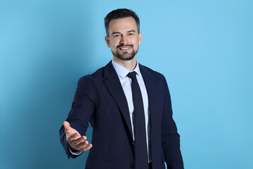 Portrait of smiling banker on light blue background